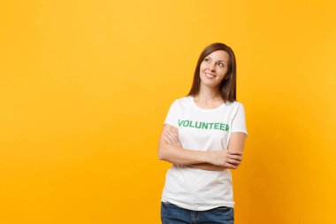 Mutlu gülümseyerek portresi beyaz t-shirt ile yazılı yazıt yeşil başlık gönüllü üzerinde sarı arka plan izole kadın memnun. Gönüllü ücretsiz destek yardım, sadaka grace iş kavramı