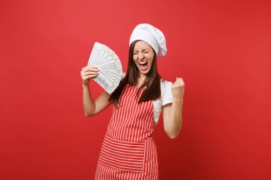 Ev hanımı kadın şef aşçı baker şapkalı izole kırmızı duvar arka plan üzerinde çizgili önlük beyaz t-shirt toque şefler. Dolar banknot bir sürü nakit para tutan heyecanlı kadın. Kopyalama alanı kavramı alay