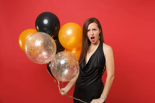 Šokovaný Podrážděný Žena Malé Černé Šaty Podržíte Balónů Slaví Izolované — Stock fotografie