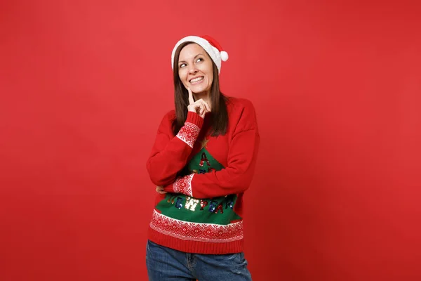 クリスマス帽子 ニット セーターで夢のようなサンタ少女は赤い背景で隔離のあごに指プロップを我慢しました 幸せな新しい年 2019年お祝いの休日党の概念 コピー スペースをモックアップします — ストック写真