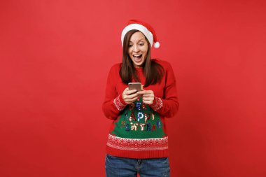 Heyecanlı Noel Baba kız tutma ağzını aç, sürpriz, cep telefonunuzun sms mesajı yazarak izole kırmızı zemin üzerine arıyorum. Mutlu yeni yıl 2019 kutlama tatil parti kavramı. Kopyalama alanı alay
