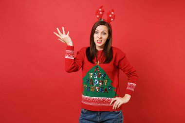 Örme kazak, parlak kırmızı zemin üzerine eller yayılan dekoratif geyik boynuzları izole eğlenceli genç Noel Baba kız söz konusu. Mutlu yeni yıl 2019 kutlama tatil parti kavramı. Kopyalama alanı alay