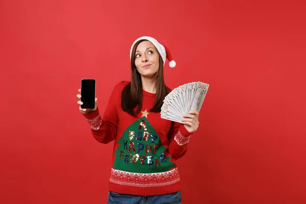 サンタ美少女たくさんたくさんドル紙幣 赤の背景に分離された空白の空の画面で現金お金の携帯電話を保持しているを探しています 幸せな新しい年 2019年お祝い休日党概念 — ストック写真