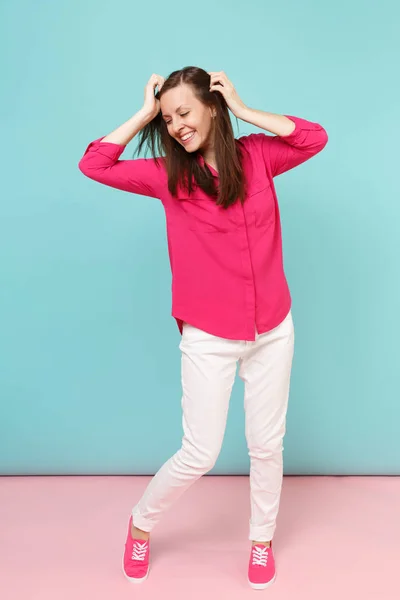 全长肖像微笑的年轻漂亮的女人在玫瑰衬衫衬衫 白色裤子摆在明亮的粉红色蓝色柔和的墙壁背景工作室孤立 时尚生活方式的概念 模拟复制空间 — 图库照片