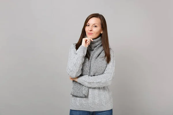 年轻女子穿着灰色毛衣围巾把手道具放在下巴上 孤立在灰色的墙上背景 工作室的肖像 健康时尚生活方式的人真诚的情绪寒冷的季节概念 模拟复制空间 — 图库照片