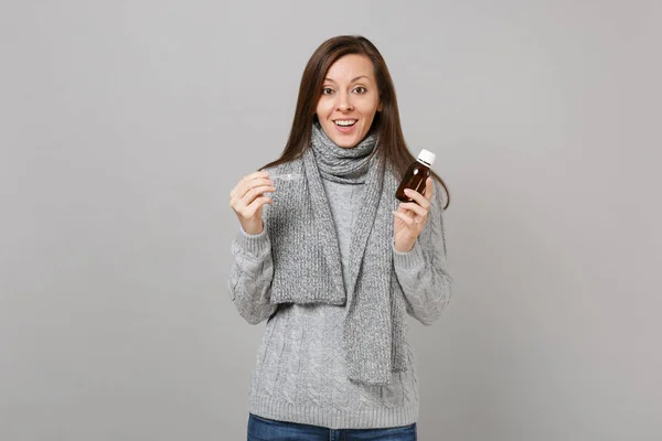 グレーのセーターに興奮した若い女性 スカーフ持株は 灰色の背景に分離されたスプーンに薬液を注ぐ 健康的なライフ スタイル 病気病気病気治療 寒い季節の概念 コピー スペースをモックアップします — ストック写真
