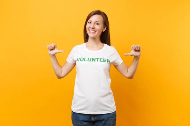 Mutlu gülümseyerek portresi beyaz t-shirt ile yazılı yazıt yeşil başlık gönüllü üzerinde sarı arka plan izole kadın memnun. Gönüllü ücretsiz destek yardım, sadaka grace iş kavramı
