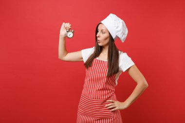 Ev hanımı kadın şef aşçı ya da baker izole kırmızı duvar arka plan üzerinde çizgili önlük, beyaz tişört, toque şefler şapkalı. Kadın tutun el gülümseyen retro çalar saat acele et. Kopyalama alanı kavramı alay