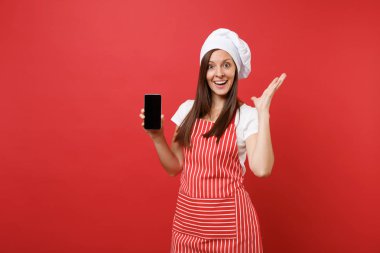 Ev hanımı kadın şef aşçı ya da çizgili önlük t-shirt toque şefler şapkalı kırmızı duvar arka plan üzerinde izole baker. Kadın cellphone yükselme içerik için boş ekran ile tutun. Kopyalama alanı kavramı alay
