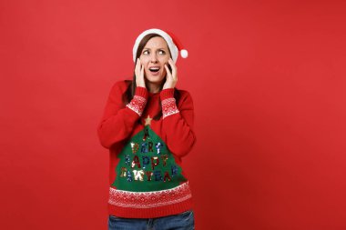 Tahriş olmuş genç Noel Baba kız Noel şapka tutuşup ararken yanaklarda parlak kırmızı zemin üzerine izole söz konusu. Mutlu yeni yıl 2019 kutlama tatil parti kavramı. Kopyalama alanı alay