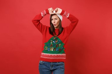 Örme kazak dokunmadan içinde Noel Baba kız Noel şapka parlak kırmızı duvar arka plan üzerinde izole el tutmak karıştı. Mutlu yeni yıl 2019 kutlama tatil parti kavramı. Kopyalama alanı alay