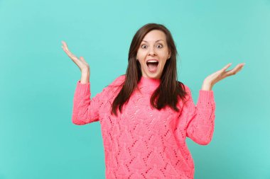 Örgü pembe kazaklı ağız eller yayılan geniş açık tutarak sürpriz genç kadın mavi duvar arka planda, stüdyo portre izole. İnsanlar samimi duygular, yaşam kavramı. Kopyalama alanı alay