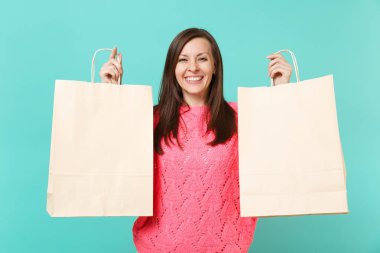 Örgü pembe kazaklı holding gülümseyen genç kadın alışveriş çantası ile satış metin yazıt mavi turkuaz duvar arka plan üzerinde izole yazılmış eller. İnsanlar yaşam tarzı kavramı. Kopyalama alanı alay