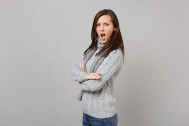 Gri süveterli, el ele tutuşarak eşarp tahriş tiksinti kadın gri arka plan üzerinde izole küfür katlanmış. Sağlıklı moda yaşam tarzı, insanlar samimi duygular, soğuk sezon kavramı. Kopyalama alanı alay