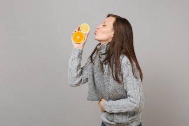 Kazaklı kadın, limon, portakal izole üzerinde gri arka plan eşarp üfleme gönderen hava öpücük yan görünüm. Sağlıklı moda yaşam tarzı, insanlar samimi duygular, soğuk sezon kavramı. Kopyalama alanı alay