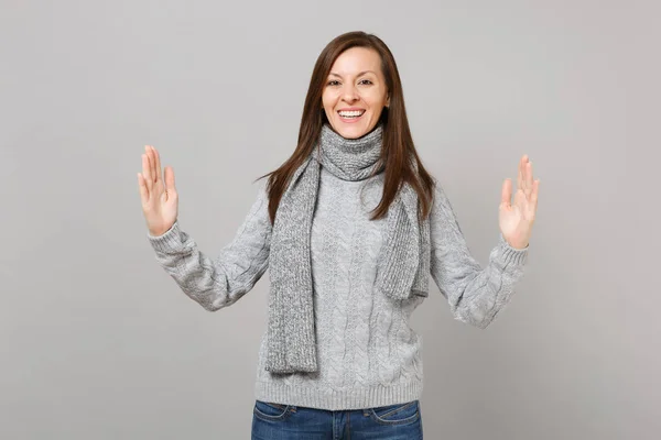 灰色のセーターのスカーフは 灰色の背景に分離された水平のワークスペースのサイズを示す身振りで示すことの少女 健康ファッション ライフ スタイルの人々 の感情寒い季節概念 コピー スペースをモックアップします — ストック写真