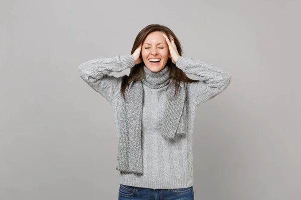 笑着穿着灰色毛衣的年轻女子 闭着眼睛的围巾把手放在头上 在灰色的墙上背景 健康时尚生活方式的人的情绪 寒冷的季节概念 模拟复制空间 — 图库照片