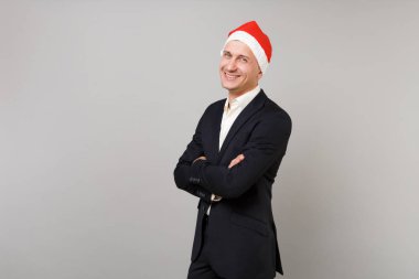 Klasik takım elbise ve el ele tutuşarak Noel şapka neşeli genç iş adamı izole üzerinde gri arka plan geçti. Başarı kariyer servet iş. Mutlu yeni yıl 2019 kutlama tatil parti konsept