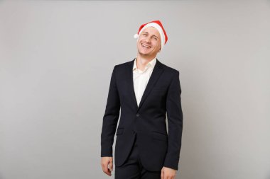 Klasik siyah takım elbise ve gri duvar arka planda Studio izole Noel şapka neşeli genç iş adamı. Başarı kariyer servet iş. Mutlu yeni yıl 2019 kutlama tatil parti konsept