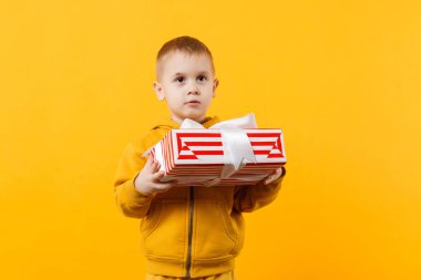 Küçük çocuk çocuk 3-4 yaşında giyen sarı giyimi turuncu duvar arka plan çocuk stüdyo portre üzerinde izole hediye kutusu tutun. İnsanlar samimi duygular, çocukluk yaşam tarzı kavramı. Kopyalama alanı alay