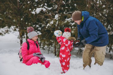 Neşeli aile kadın adam ve küçük kız kış sıcak giysiler içinde karlı park veya orman mekanlarda olun kartopu oynamak. Kış eğlence, dinlence tatil günlerinde. Aşk ilişki aile insanların yaşam tarzı kavramı