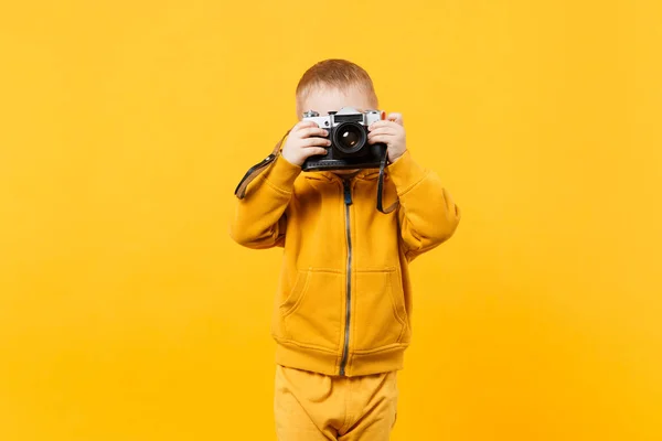 Dítě Chlapeček Let Žluté Oblečení Držet Fotoaparát Izolované Oranžové Zdi — Stock fotografie