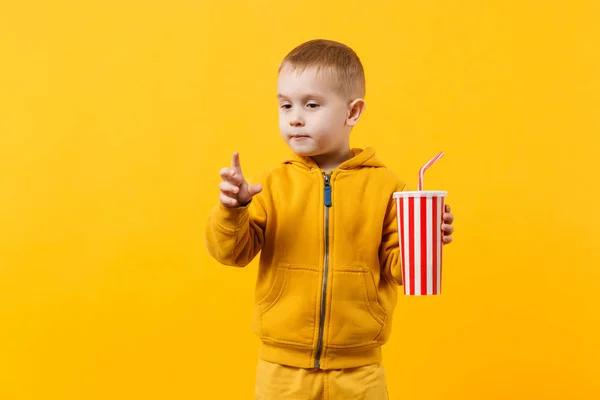 小乐趣开朗的男孩 穿着黄色衣服举行一杯苏打水隔离在橙色的墙壁背景 儿童工作室肖像 童年生活方式的概念 模拟复制空间 — 图库照片