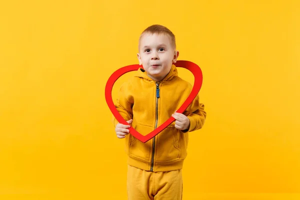 Dítě Chlapeček Let Žluté Oblečení Drží Červené Srdce Izolované Oranžové — Stock fotografie