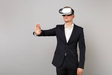 Kulaklık temas arıyor takım elbiseli Genç iş adamı itme gibi bir şey tıklayın düğmesini ve gri arka plan üzerinde izole sanal ekran yüzen işaret. Başarı kariyer servet iş kavramı