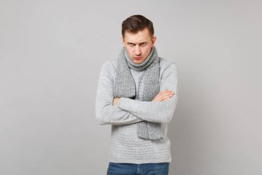 Sıkı genç adam gri süveterli Studio gri duvar arka plan üzerinde çarpı işareti el ele tutuşarak eşarp izole. Sağlıklı moda yaşam tarzı, insanlar samimi duygular, soğuk sezon kavramı. Kopyalama alanı alay