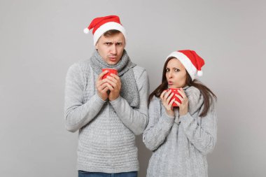 Kırmızı Santa Noel şapka gri kazak eşarp eğlenceli çift kız adam gri duvar arka planda, stüdyo portre izole çay bardak tutun. Mutlu yeni yıl 2019 tatil parti kavramı. Kopyalama alanı alay
