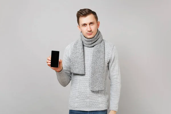 Młody Człowiek Szary Sweter Szalik Trzymając Telefon Komórkowy Puste Pusty — Zdjęcie stockowe