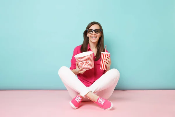 全长肖像妇女在玫瑰衬衫 白色裤子坐在地板上看电影电影孤立在明亮的粉红色蓝色柔和墙背景工作室 时尚生活方式的概念 模拟复制空间 — 图库照片