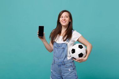 Futbol topu, cep telefonu mavi turkuaz arka plan üzerinde izole boş boş ekran ile tutarak dreamful kız futbol fanatiği. İnsanların duyguları, spor aile eğlence yaşam tarzı kavramı. Kopyalama alanı alay
