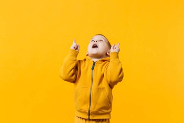 Küçük şirin çocuk çocuk 3-4 yıl sarı elbise giyen eski parlak turuncu duvar arka planda, çocuk stüdyo portre izole. İnsanlar samimi duygular, çocukluk yaşam tarzı kavramı. Kopyalama alanı alay