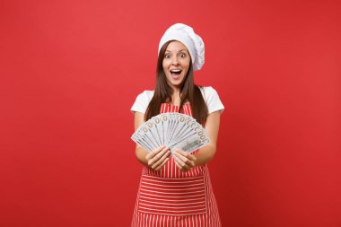 Ev hanımı kadın şef aşçı baker izole kırmızı duvar arka plan üzerinde çizgili önlük, beyaz tişört, toque şefler şapkalı. Dolar banknot bir sürü nakit para tutan mutlu kadın. Kopyalama alanı kavramı alay