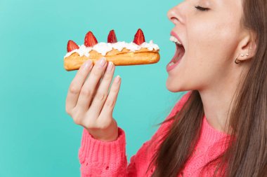 Kırpılmış görüntü ile örme pembe kazaklı genç kadının gözleri tutun el, mavi duvar arka planda, stüdyo portre izole pasta pasta yemeye kapalı. İnsanlar yaşam tarzı kavramı. Kopyalama alanı alay
