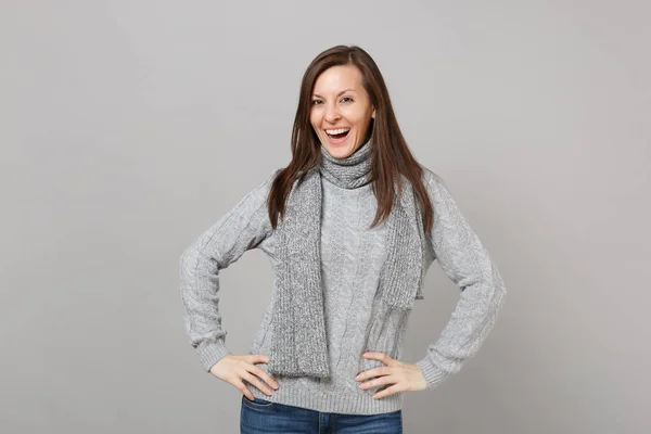 灰色のセーター スカーフに当ててスタジオの灰色の背景上で分離の側に立っての若い女性を見事な 健康的なファッションのライフ スタイルの人々 の誠実な感情 寒い季節の概念 コピー スペースをモックアップします — ストック写真