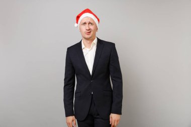 Noel şapka Studio gri duvar arka plan üzerinde izole klasik siyah elbiseli genç iş adamı şaşkın. Başarı kariyer servet iş. Mutlu yeni yıl 2019 kutlama tatil parti konsept