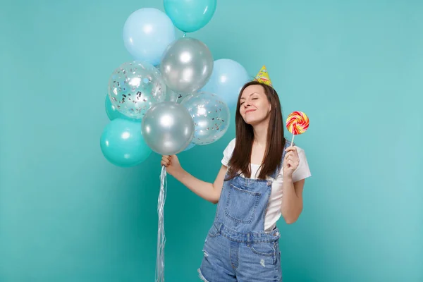 Mujer Relajada Sombrero Cumpleaños Manteniendo Los Ojos Cerrados Sosteniendo Piruleta —  Fotos de Stock