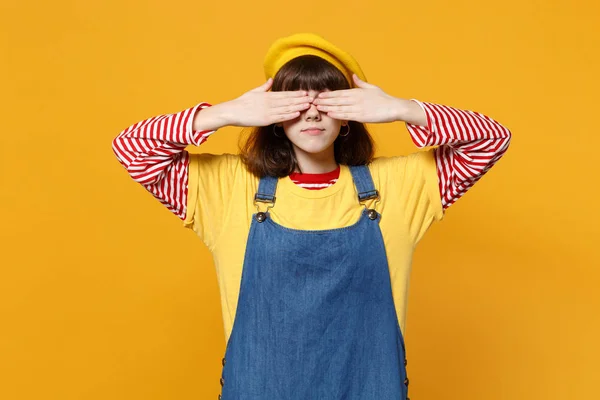漂亮的女孩十几岁的肖像在法国贝雷帽 牛仔太阳裙覆盖眼睛与手隔离在黄色的墙壁背景在工作室 人们真诚的情感 生活方式的理念 模拟复制空间 — 图库照片