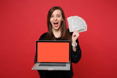 Dizüstü pc bilgisayar boş boş ekran fan Doları banknot para ile izole kırmızı zemin üzerine nakit para tutan heyecanlı kadın. İnsanlar samimi duygular, yaşam kavramı. Kopyalama alanı alay
