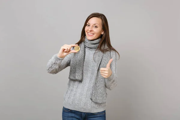 有吸引力的女人在灰色毛衣 围巾显示拇指拿着比特币 未来的货币隔离在灰色的背景 健康时尚的生活方式 人们的情感 寒冷的季节概念 模拟复制空间 — 图库照片