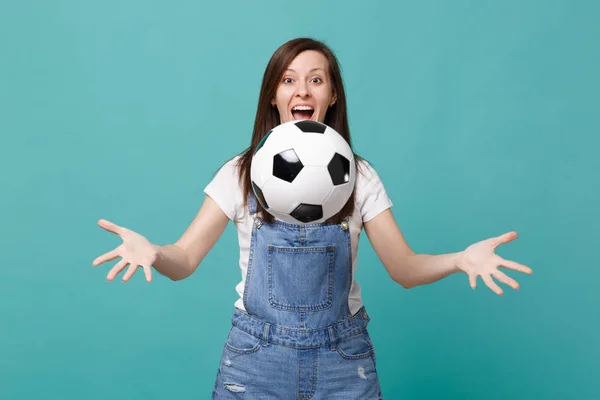 Surprised funny young woman football fan cheer up support favorite team throwing soccer ball isolated on blue turquoise background. People emotions, sport family leisure concept. Mock up copy space