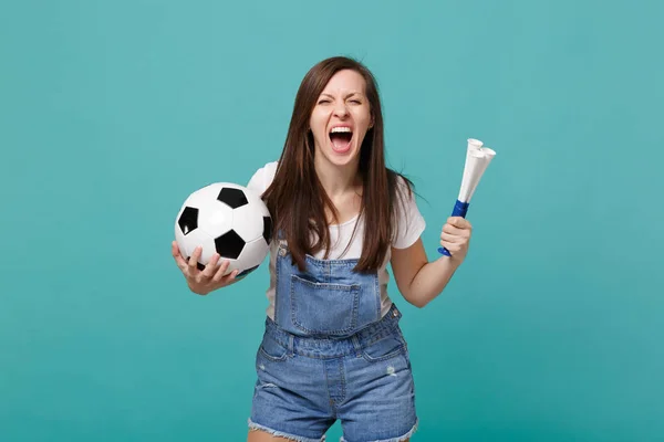 Screaming wild woman football fan cheer up support favorite team with soccer ball, pipe isolated on blue turquoise wall background. People emotions, sport family leisure concept. Mock up copy space