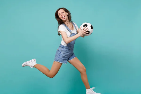 Funny woman football fan cheer up support favorite team holding soccer ball jumping isolated on blue turquoise background. People emotions, sport family leisure lifestyle concept. Mock up copy space