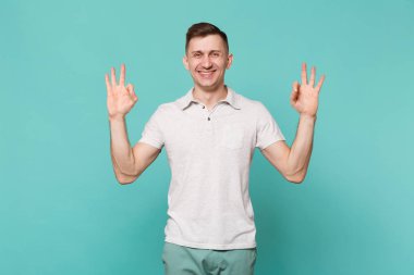 Genç gülümseyen adam rahat kıyafetler içinde el ele tutuşsun Ok jest mavi turkuaz duvar arka planda Studio izole gösterilen yoga jest olarak. İnsanlar samimi duygular, yaşam kavramı. Kopyalama alanı alay