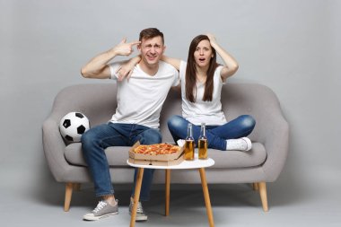 Meşgul çift kadın adam futbol taraftarları destek favori takım noktası parmak kafa sanki kendini gri arka plan üzerinde izole vurmuş hakkında tezahürat. İnsanların duyguları, spor aile eğlence kavramı