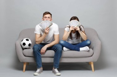 Şok Çift kadın adam futbol taraftarları destek favori takım tutma yüz dolarlık banknot, gri arka plan üzerinde izole nakit para para Fanlı kapsayan, neşelen. Spor aile yaşam tarzı kavramı