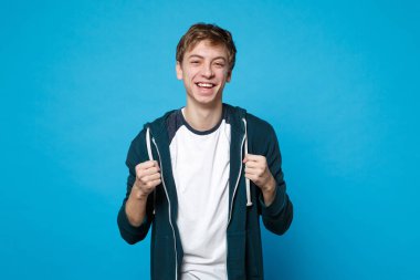 Çekici gülen neşeli genç adam ayakta, mavi duvar arka planda Studio izole yumruk kenetlenmesi rahat kıyafetler portresi. İnsanlar samimi duygular, yaşam kavramı. Kopyalama alanı alay